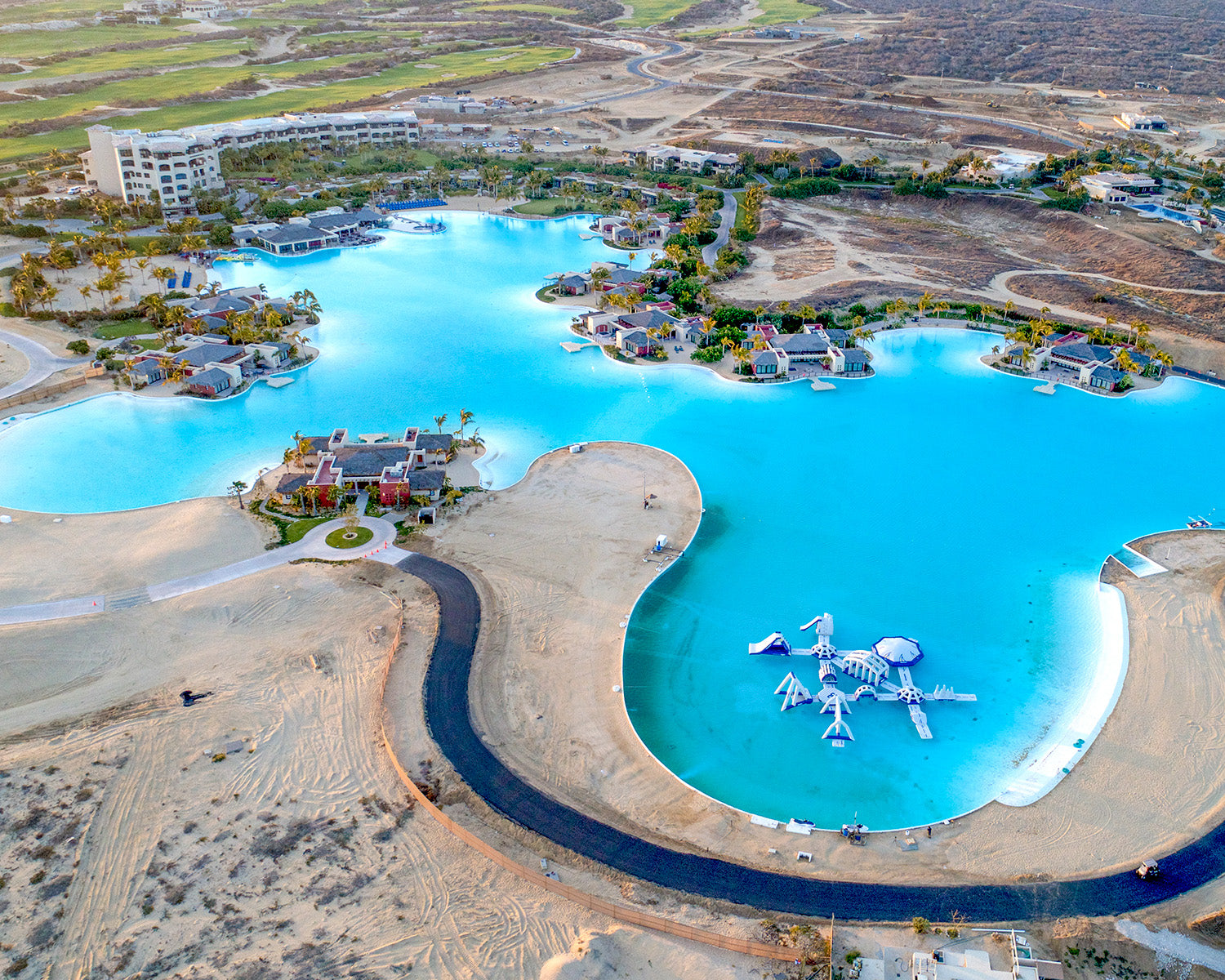 Aerial view of tropical lagoon with villas and inflatable water park.