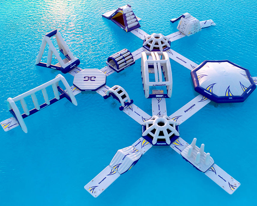 Floating inflatable water park with slides and climbing sections on a blue water surface.