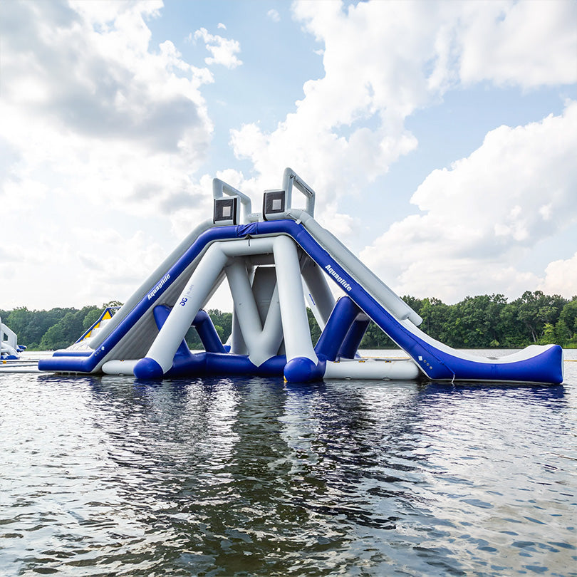 El Jefe: An inflatable water slide on a lake, ideal for adrenaline junkies under cloudy skies.