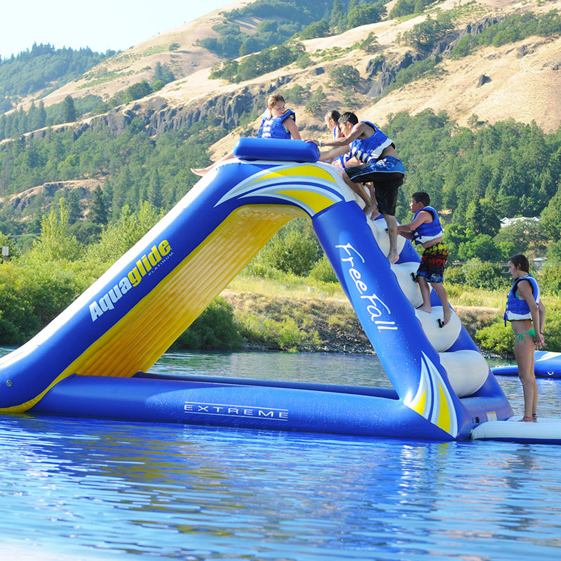 People climb the Freefall Extreme slide on a lake at the Aquaglide Aquapark.