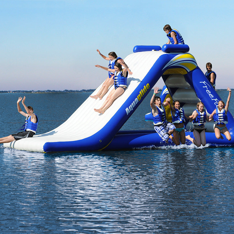 People enjoying Freefall Extreme, jumping into the lake from a giant inflatable adventure slide.