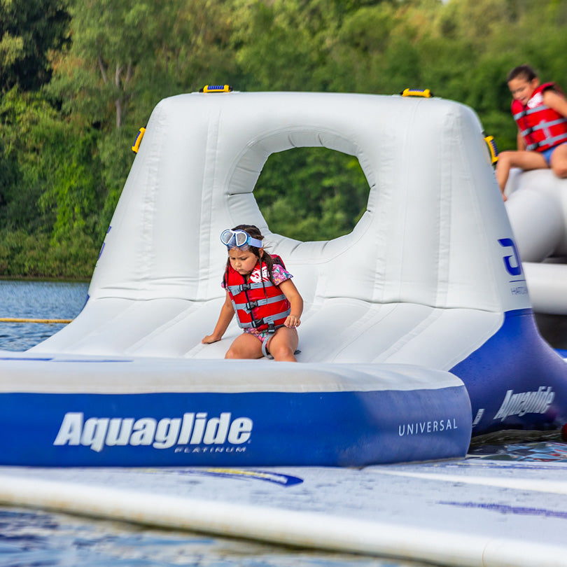 Child in a Hatchway 10 life jacket sliding down an aquapark track.