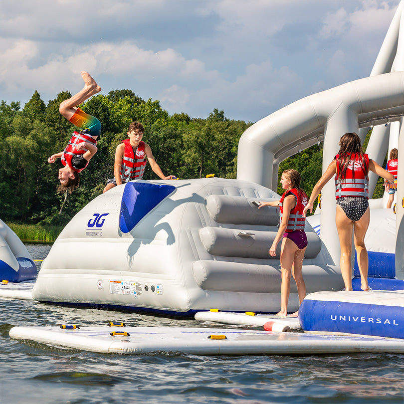 Kids on Ridgeway 10 at aquapark, one doing a backflip on the inflatable structure.
