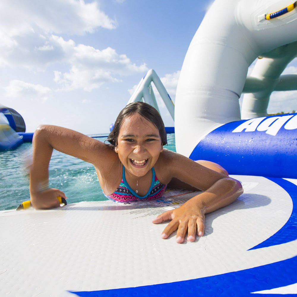 Girl smiling and playing on Speedway 10 inflatable obstacle course.