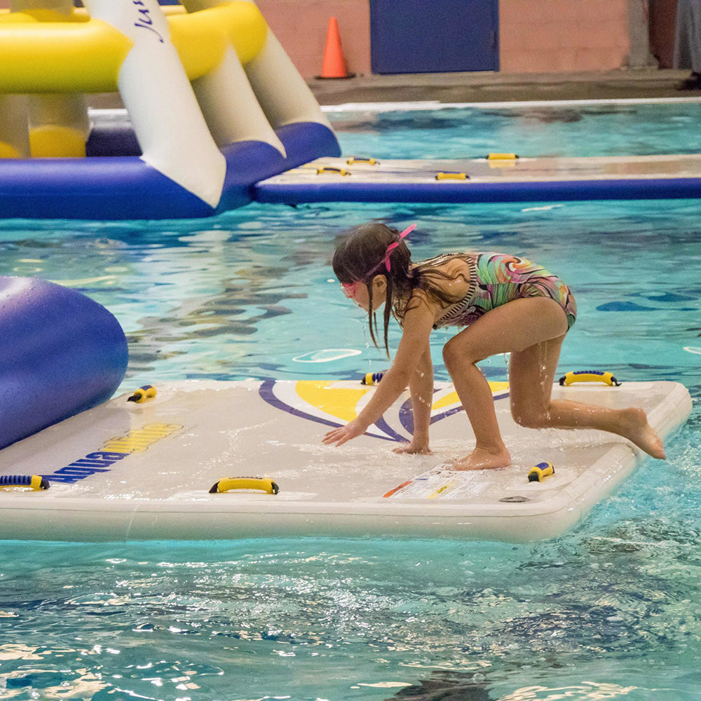 Child in Swimstep XL swimwear and goggles exploring a platform in the pool.