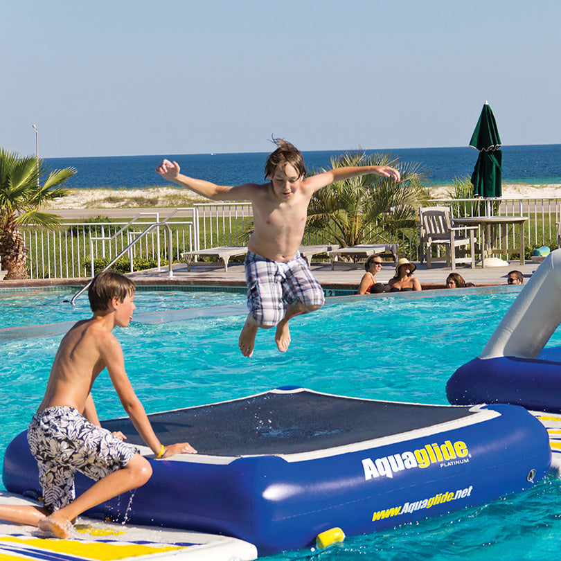 Child bounces on Tango inflatable in a pool at an Aquaglide Aquapark.