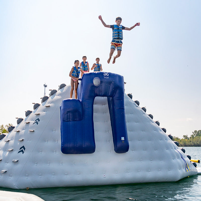 Children on a Thor water slide; one jumps off the high-velocity chute.