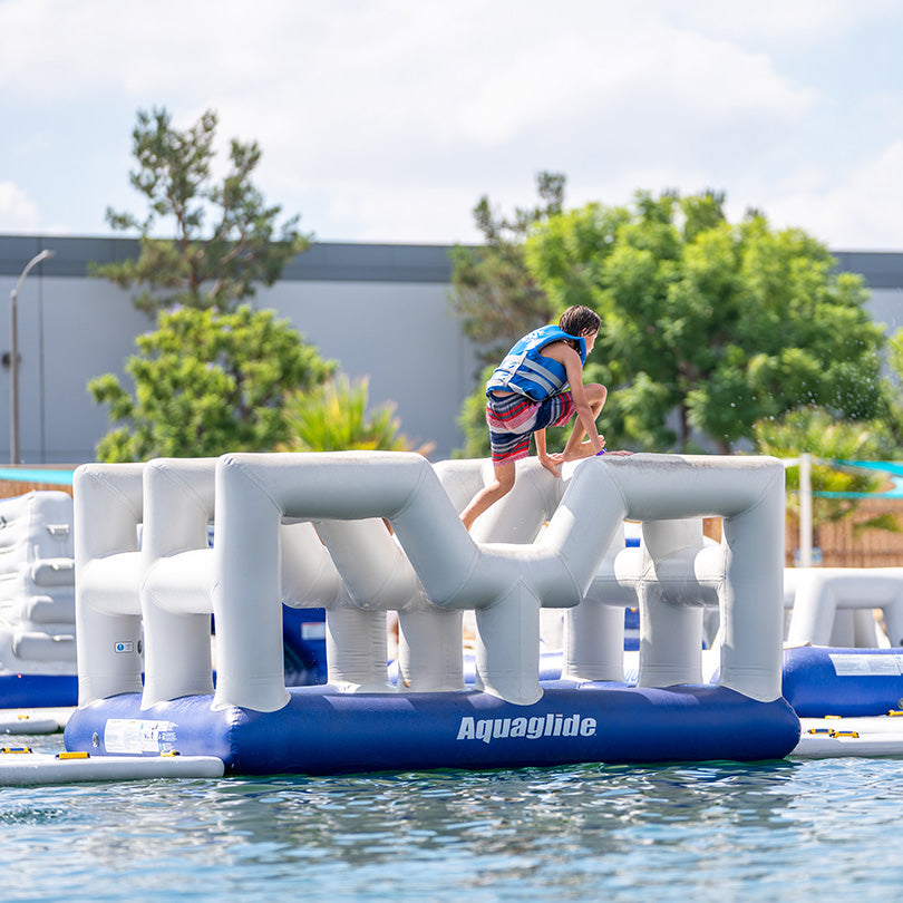 Climber on a Vista 10 inflatable Aquaglide course in a life jacket.
