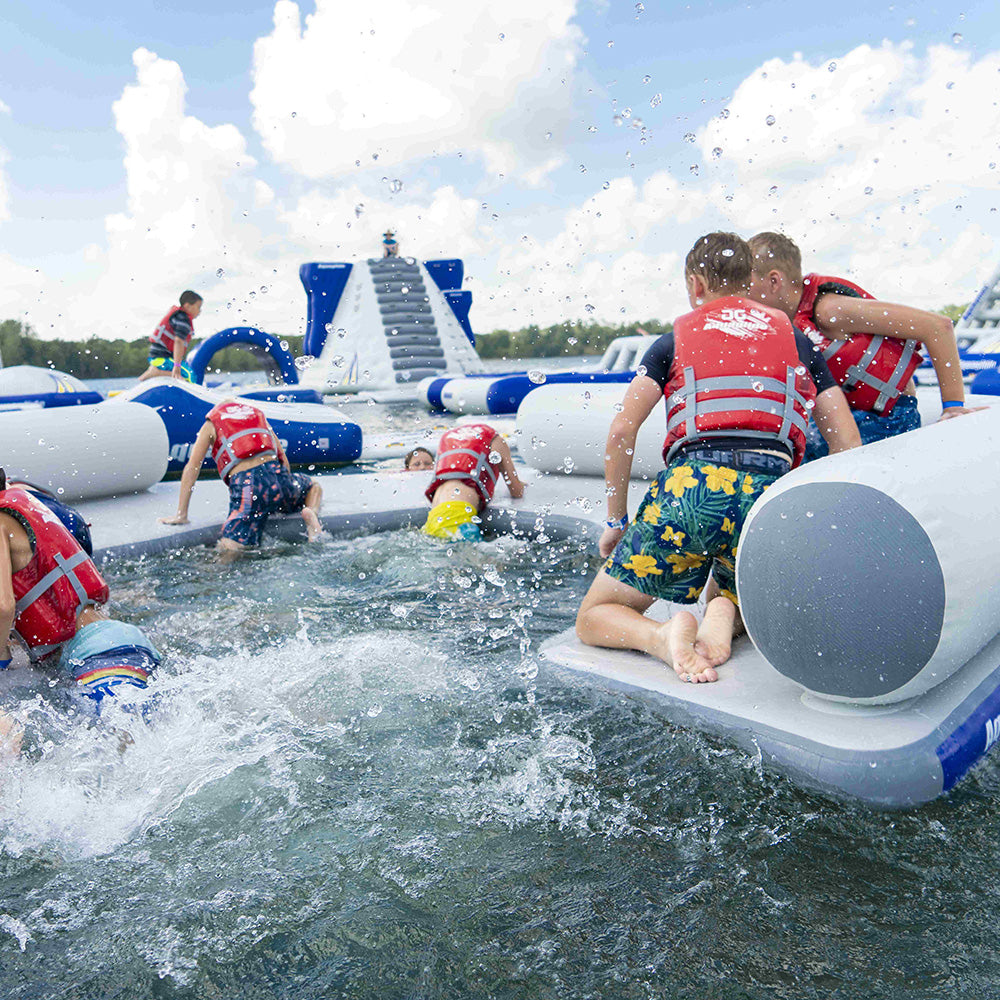 Kids enjoying the C Lounge on a lake, all wearing life vests.