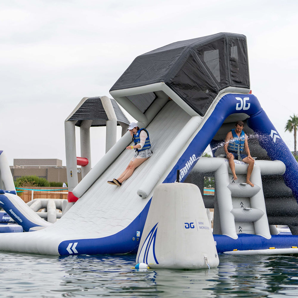 Two people enjoy the Freefall Supreme TR zero-entry slide into the water.