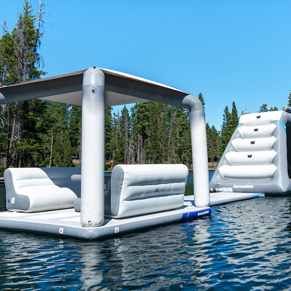 Lakefront Mini Park 4: Inflatable dock with canopy and slide on a tree-lined lake.