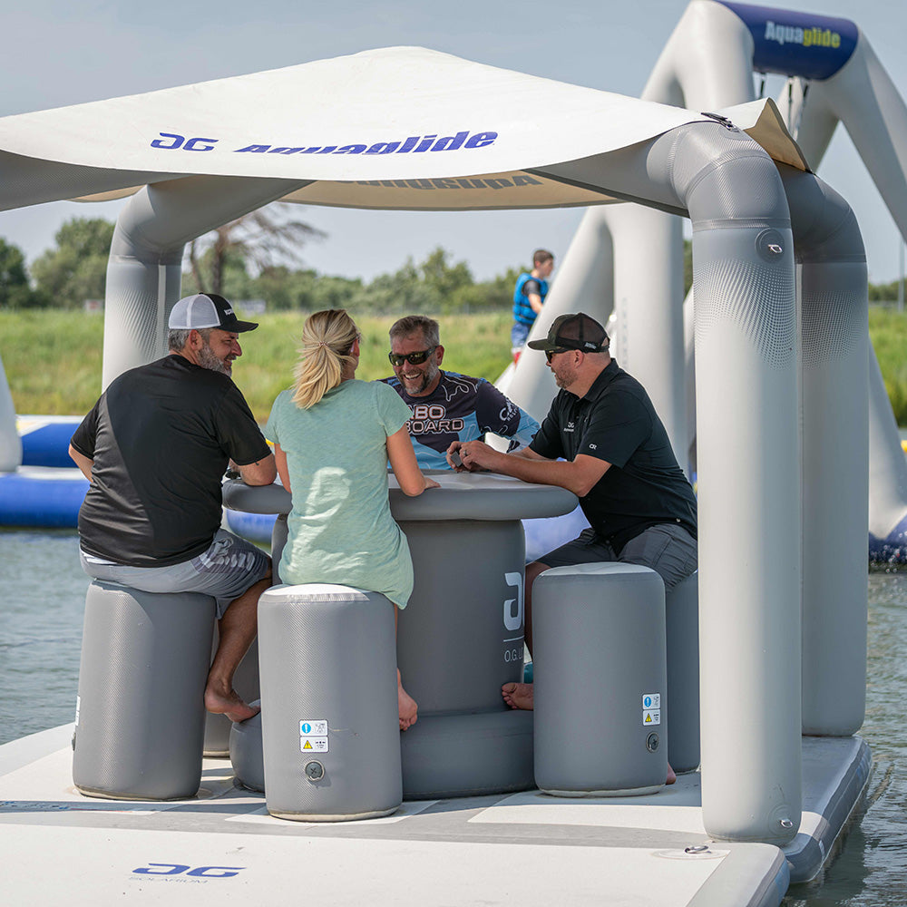 Four friends chat at an OG Lounge on the water.