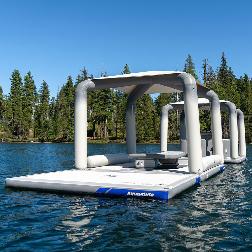 Solarium inflatable lounge on lake with forest and clear blue sky.