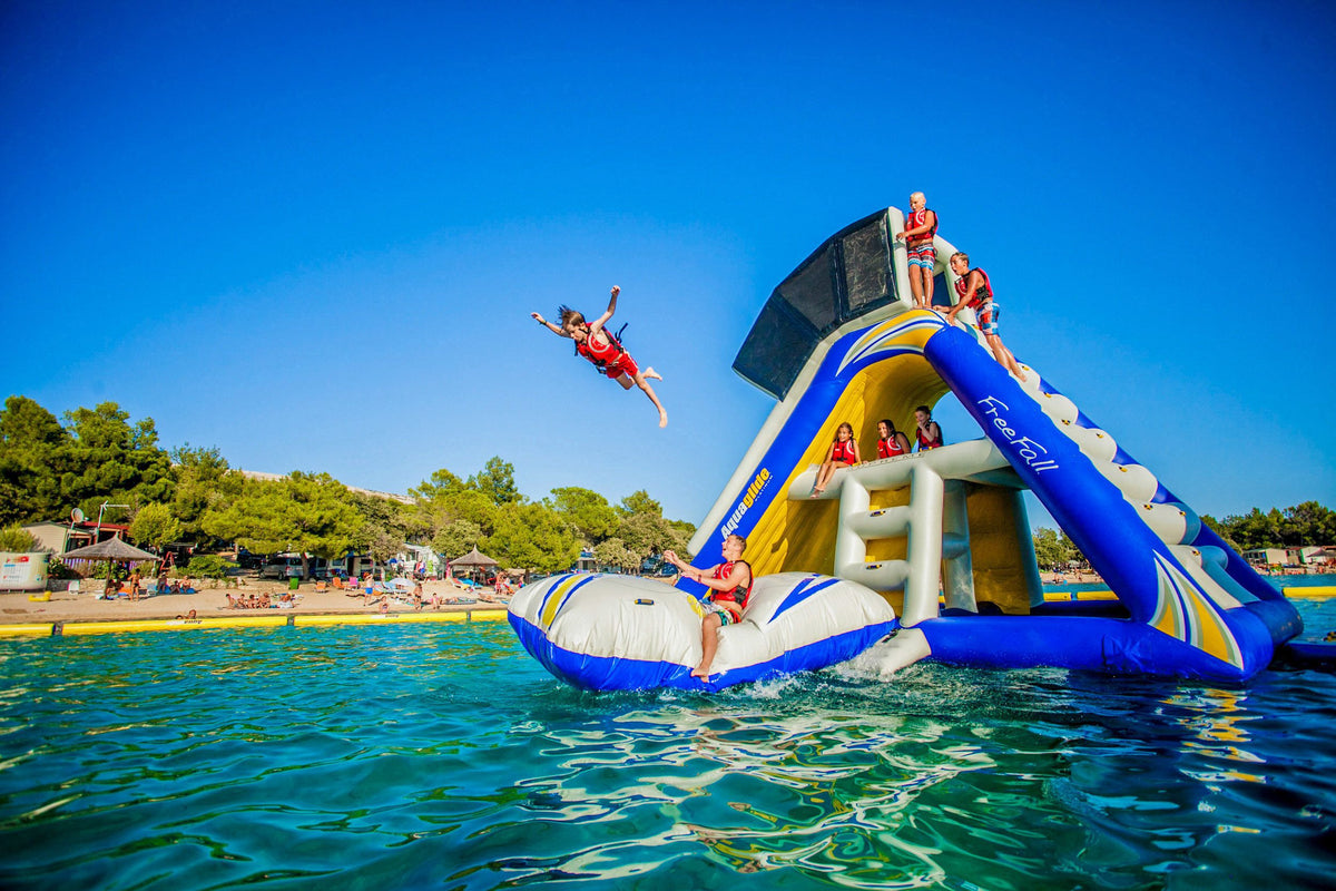 Person leaps from a Blast Bag into the sea on a sunny day.