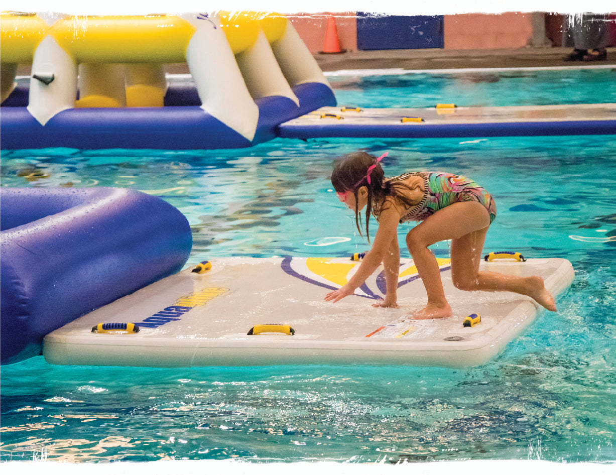 A kid climing on an Aquaglide mat