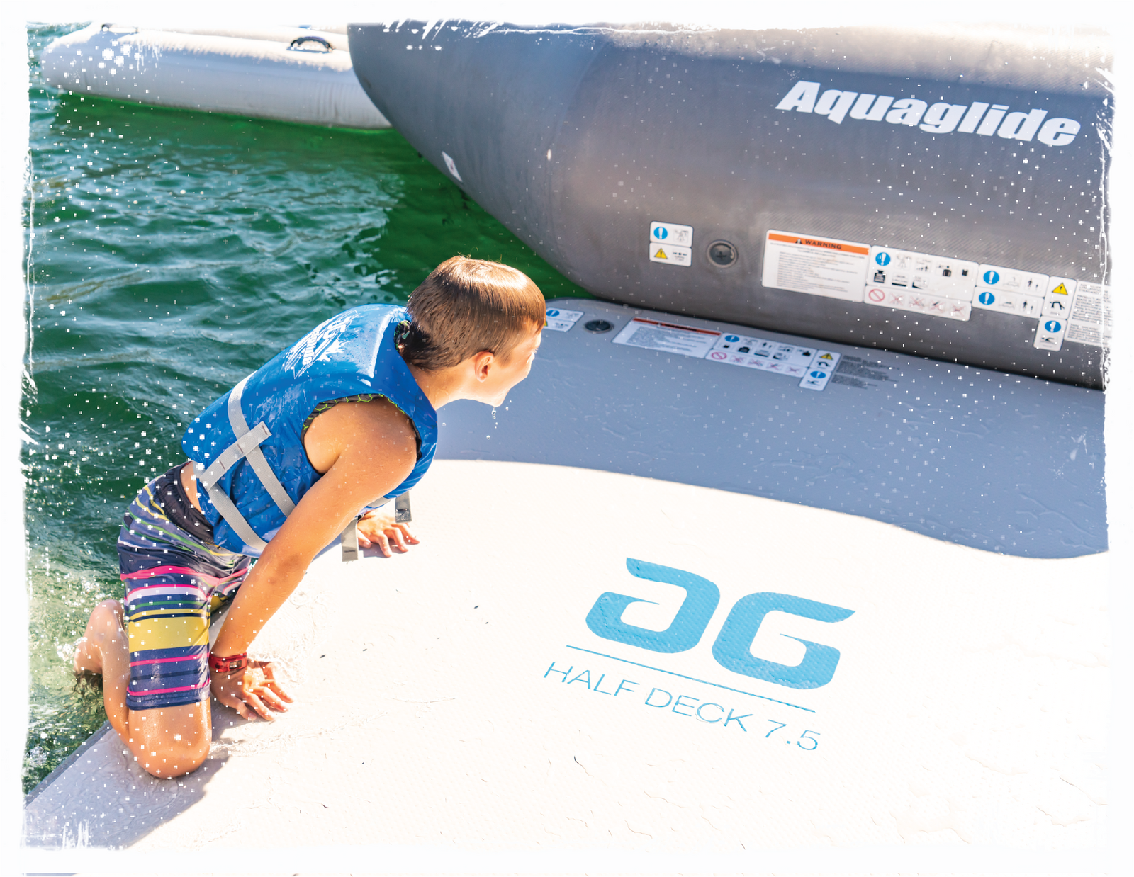 Single swimmer climbing on top of floating Aquaglide deck with grey and blue logos  and colors