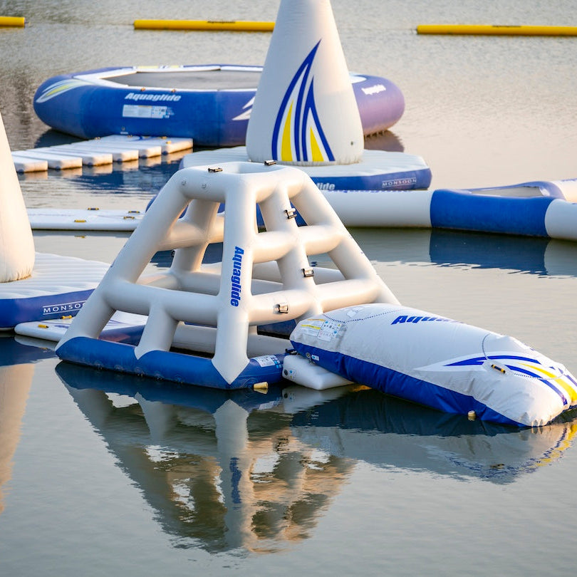 Overview of the Aquaglide Jungle Joe, Launch pad, Monsoon and more attached in a floating aquapark ready for swimmers to jump in.
