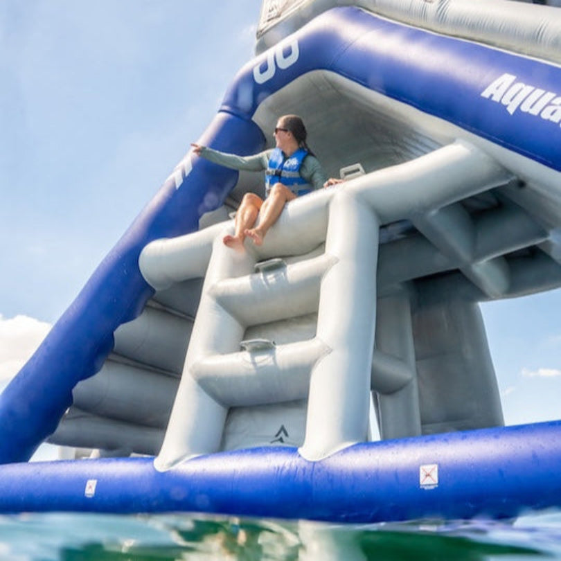 Person sitting in the middle of the Freefall Supreme from Aquaglide sitting on top of the stairs