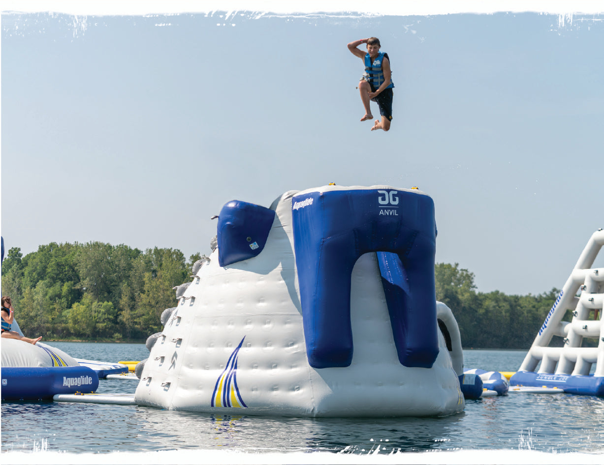 A boy jumping off the Anvil climbing wall structure