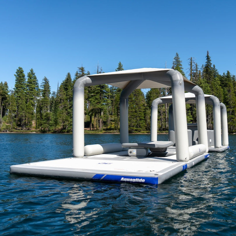 Solarium inflatable lounge on lake with forest and clear blue sky.