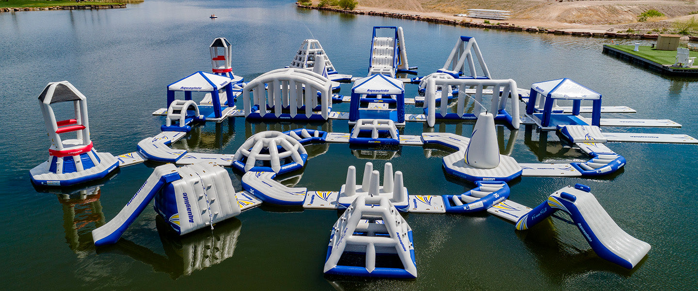Inflatable water park with slides and obstacles on a lake.