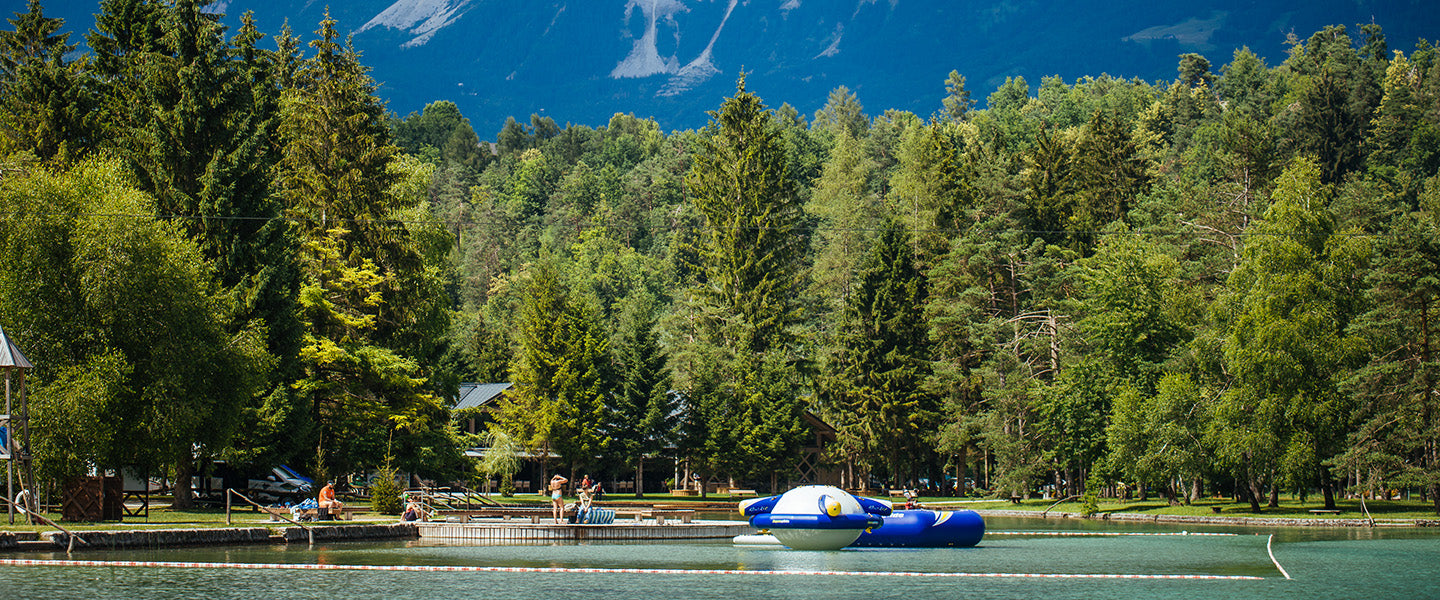 Paddle boat on a forested lake with mountain in the background.