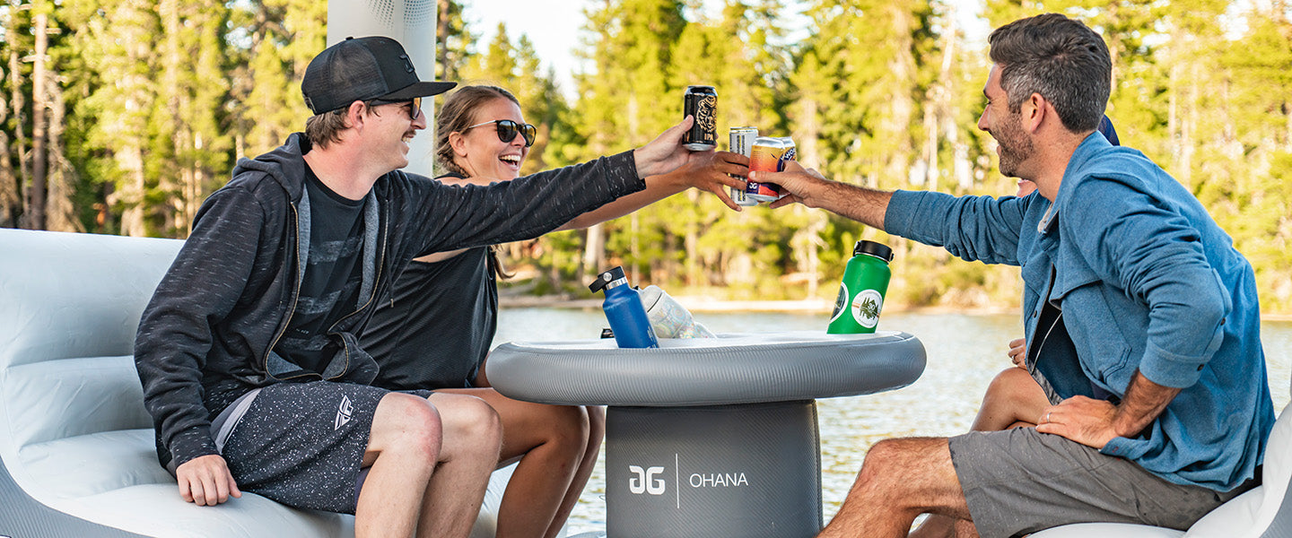 Three friend raise a toast on the Aquaglide Ohana with trees in the background.