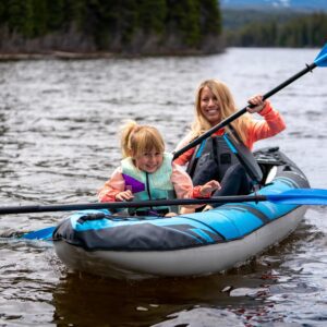 A mom and little girl paddle the Chinook 100 and smile at the camera