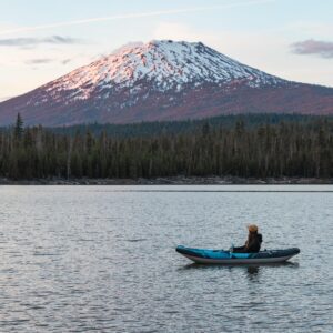 Paddler in Chinook 90 looks out onto Mt Bachelor with sunset alpenglow