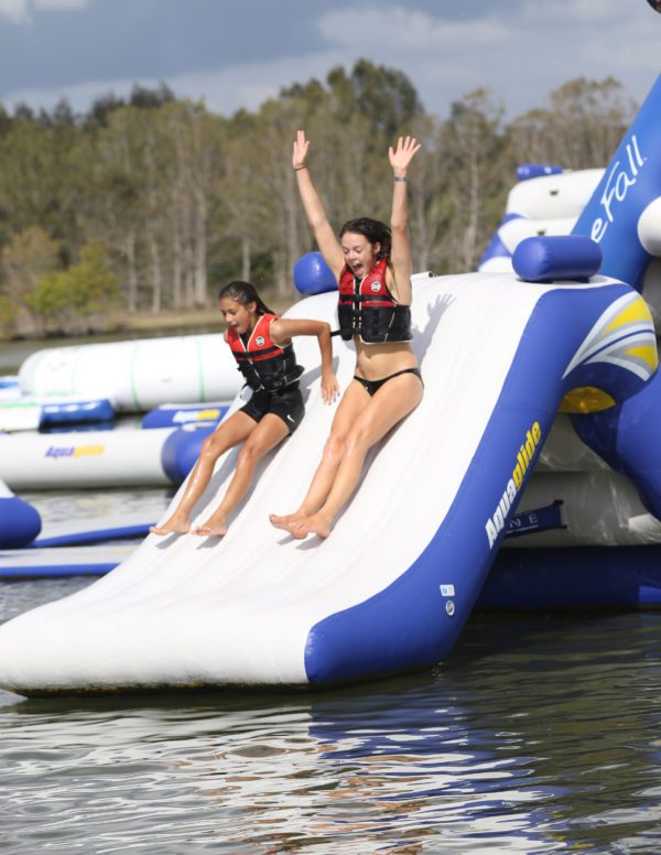 Two girls laughing while sliding down the Freefall 6