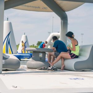 Parents watch their kids play on the aquapark in the background while resting on the OG lounge